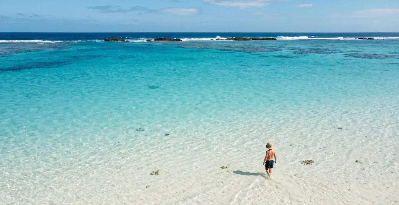 Tranquil turquoise lagoon with crystal-clear shallow water inside protective barrier reef ideal for young children to swim safely
