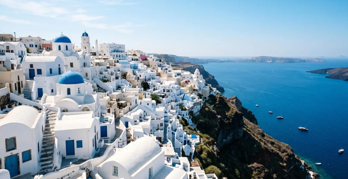 Stunning whitewashed Mediterranean island architecture with blue-domed churches cascading down hillside toward azure sea