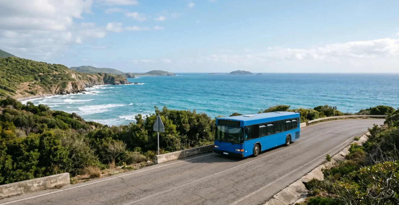 Wide-angle view of a public bus on a winding coastal island road with tropical landscape and ocean in background